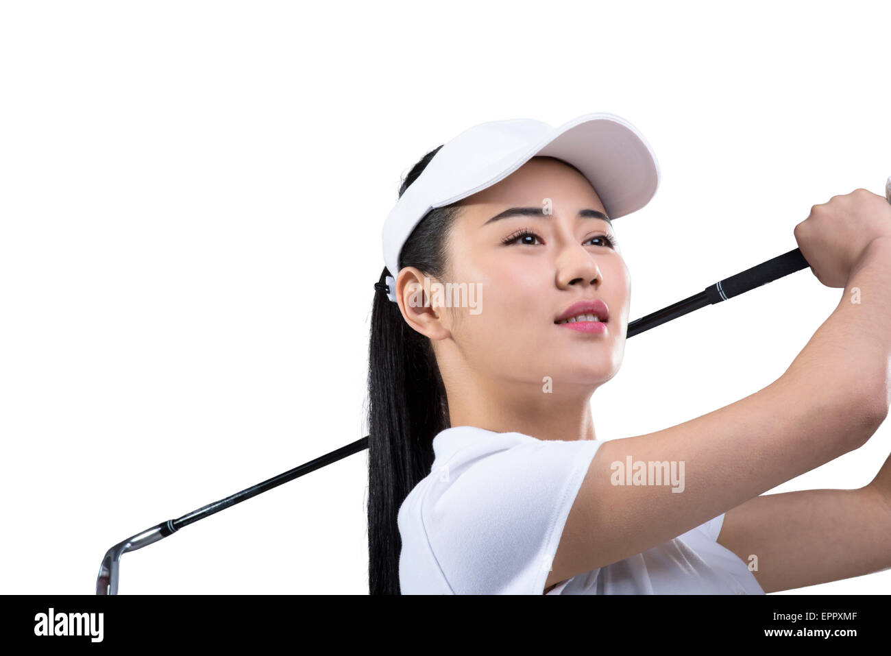 Young female golfer swinging golf club Stock Photo