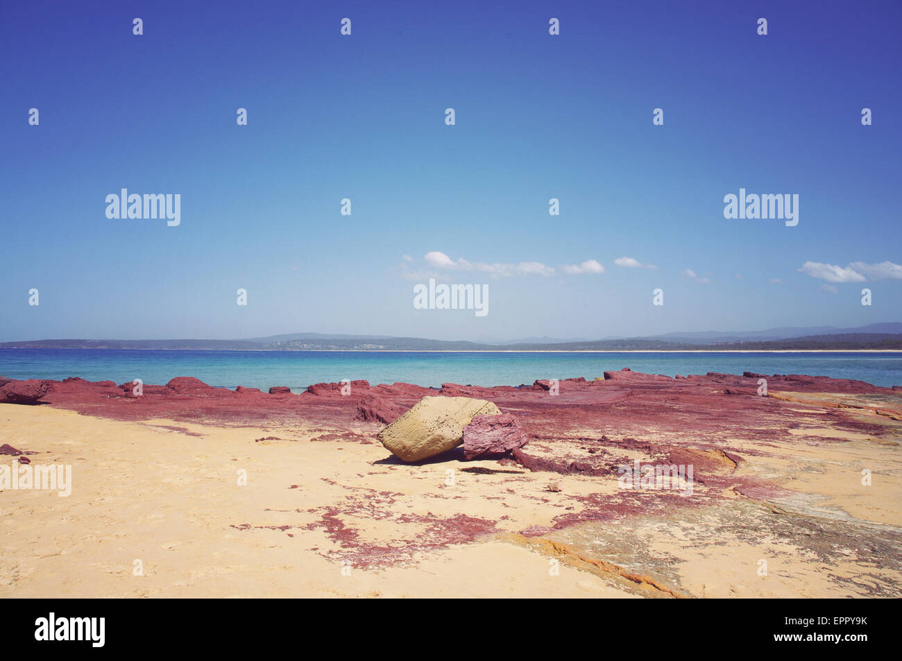 Sand, Red Rock and Turquoise water Stock Photo