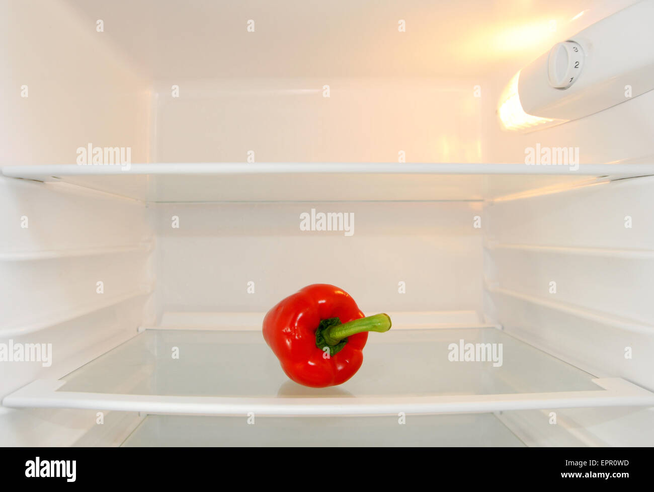 Single red pepper sitting alone in an empty fridge Bell pepper, also