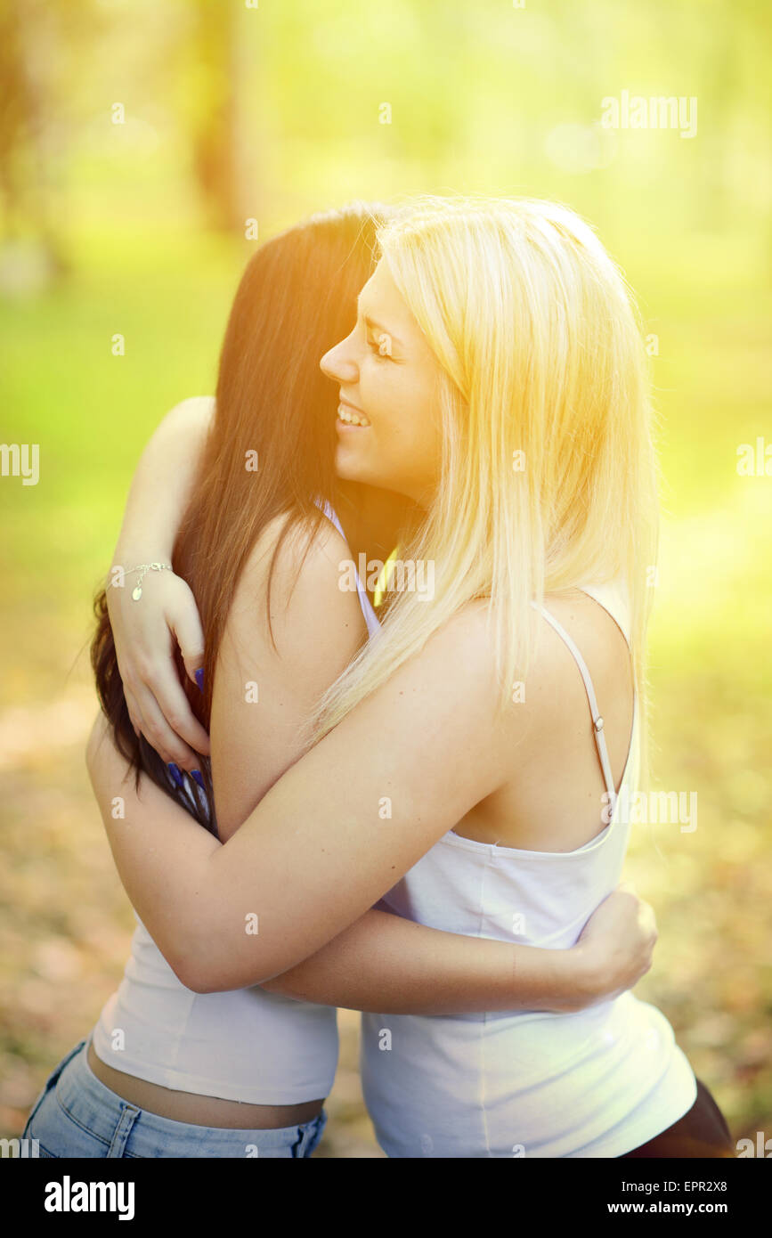 Close up portrait of two happy girls hugging outdoors Stock Photo - Alamy