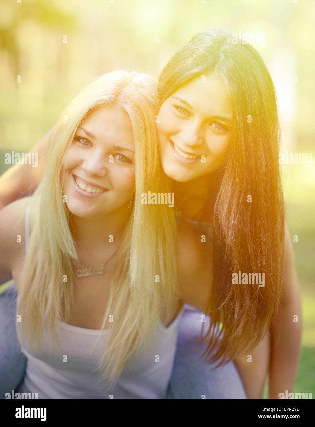 Close up portrait of two happy girls hugging outdoors Stock Photo - Alamy