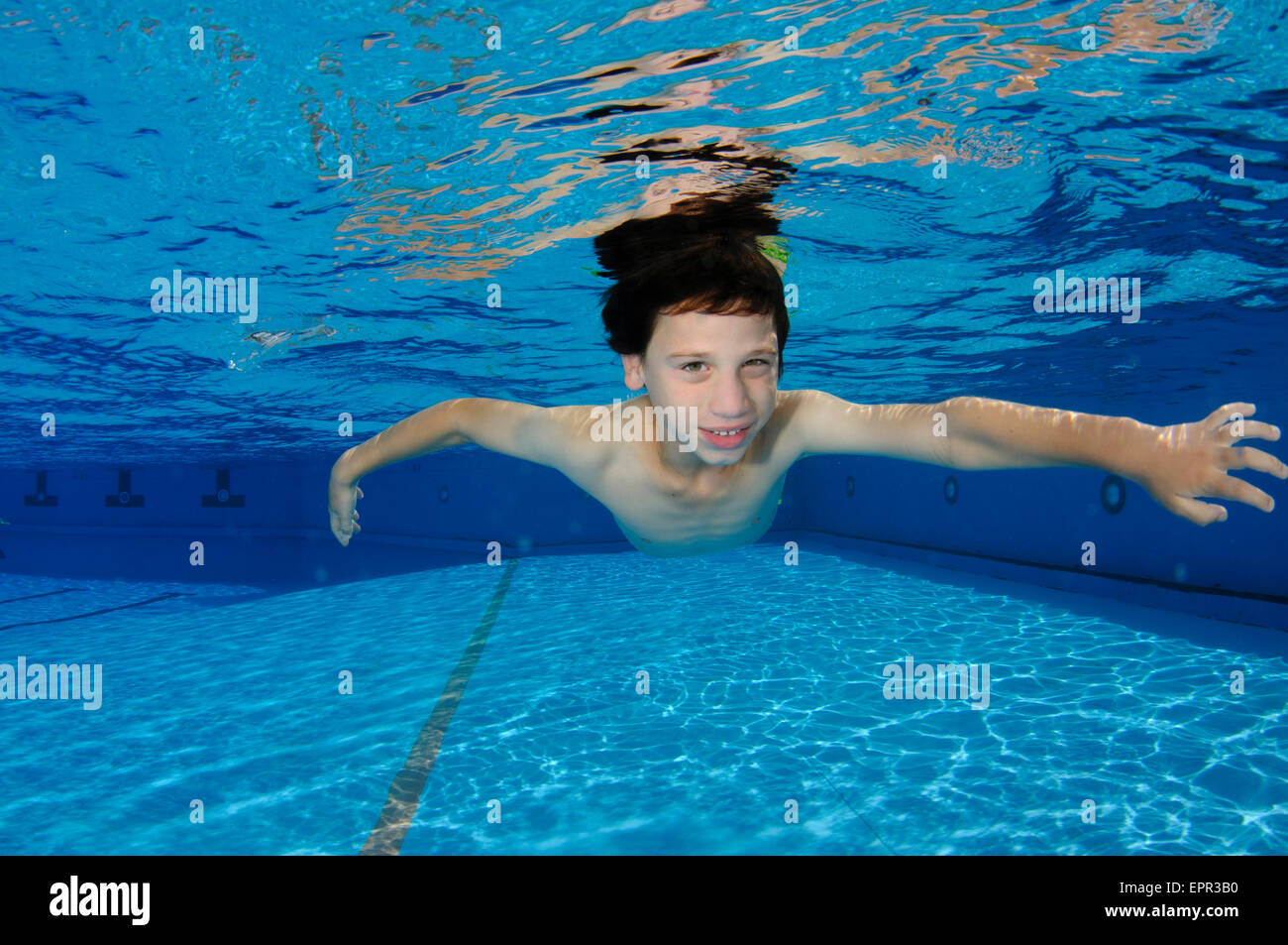 Young boy holds her breath while swimming underwater Stock Photo