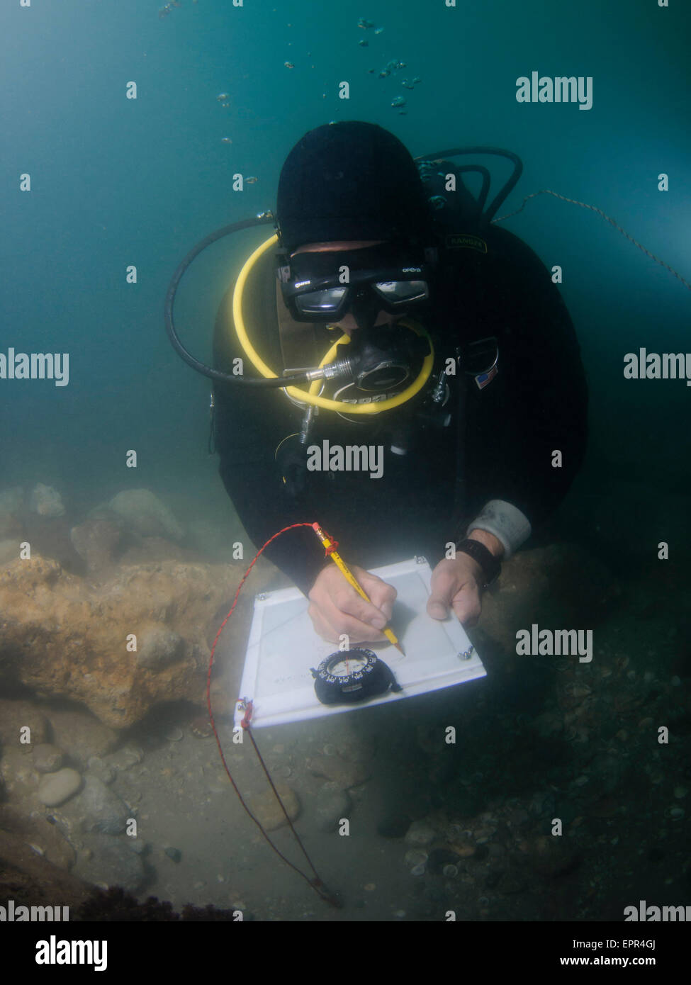 Underwater survey. Scuba diver uses a clip chart and compass Stock Photo