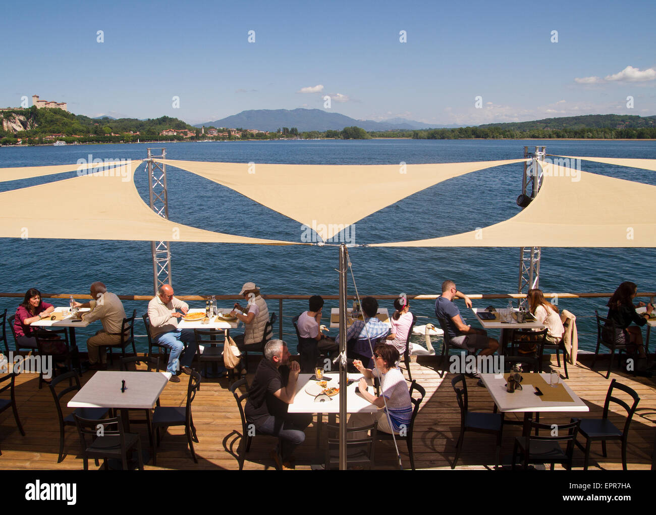 diners eating at a lakeside restaurant in Arona, lake Maggiore, Italy Stock Photo