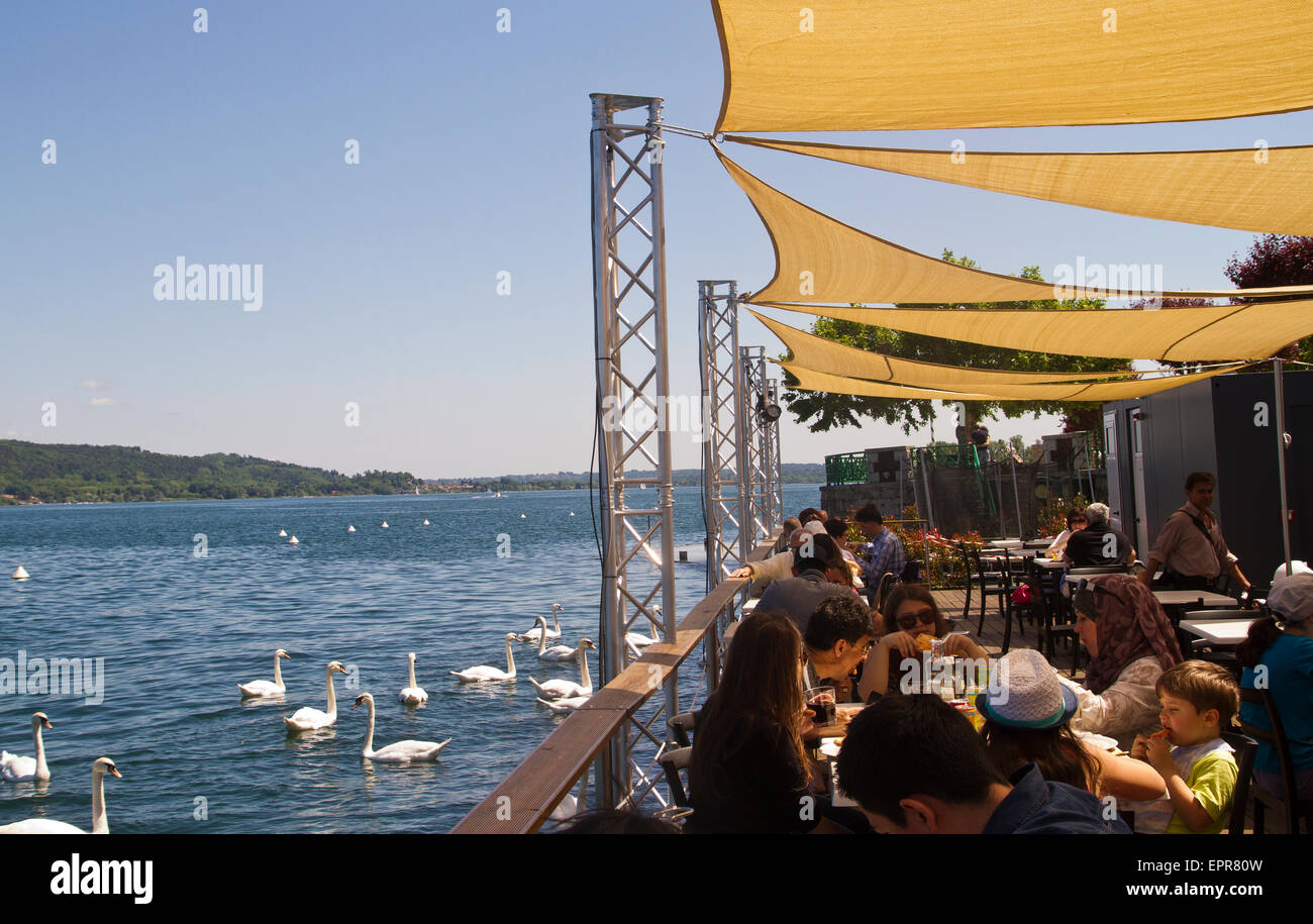 diners enjoying lunch at a lakeside restaurant in Arona, Lake Maggiore, Italy Stock Photo