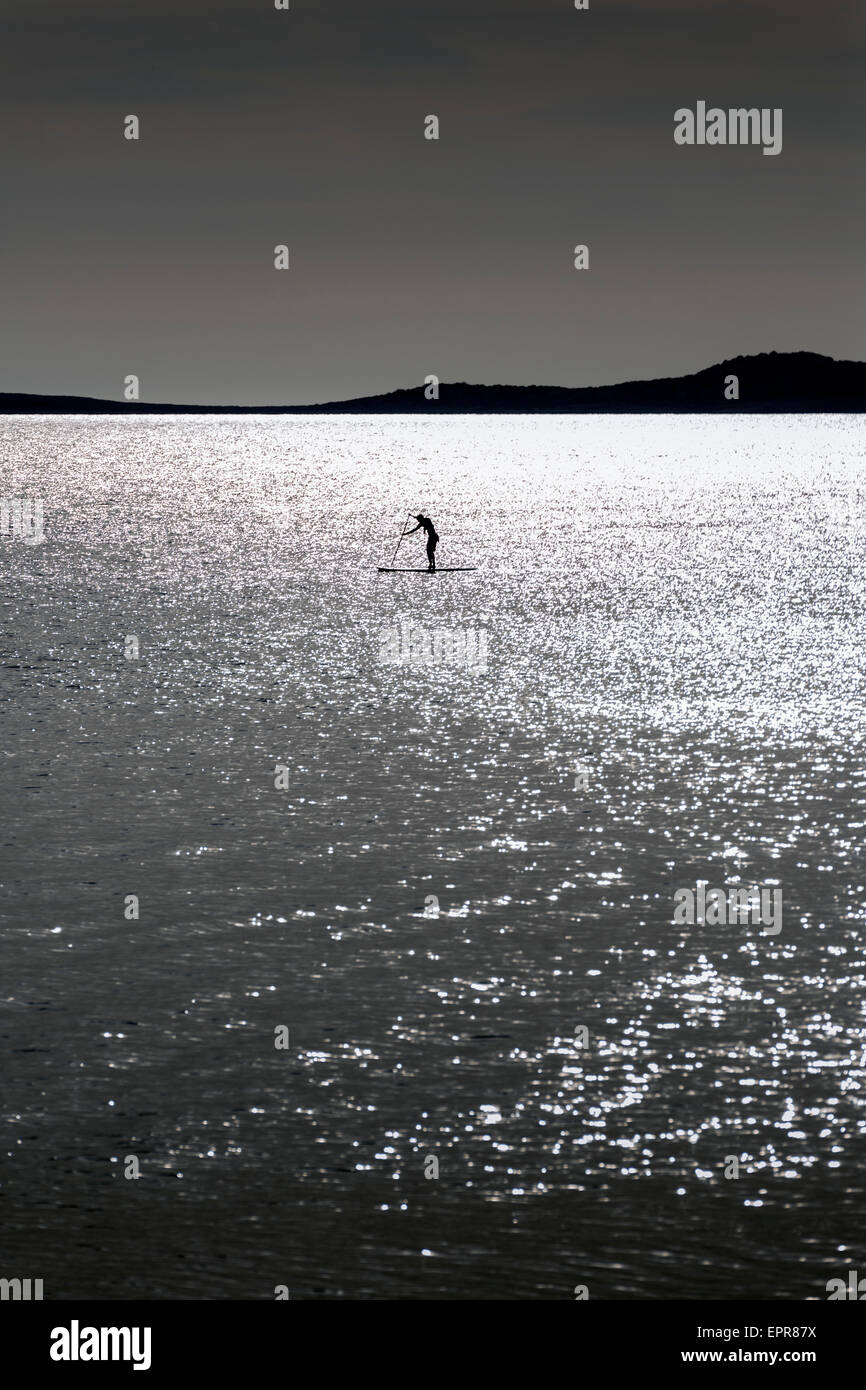 Silhouettes of Stand up paddle surfers (paddle boarders) at sunset. Ibiza coast Stock Photo