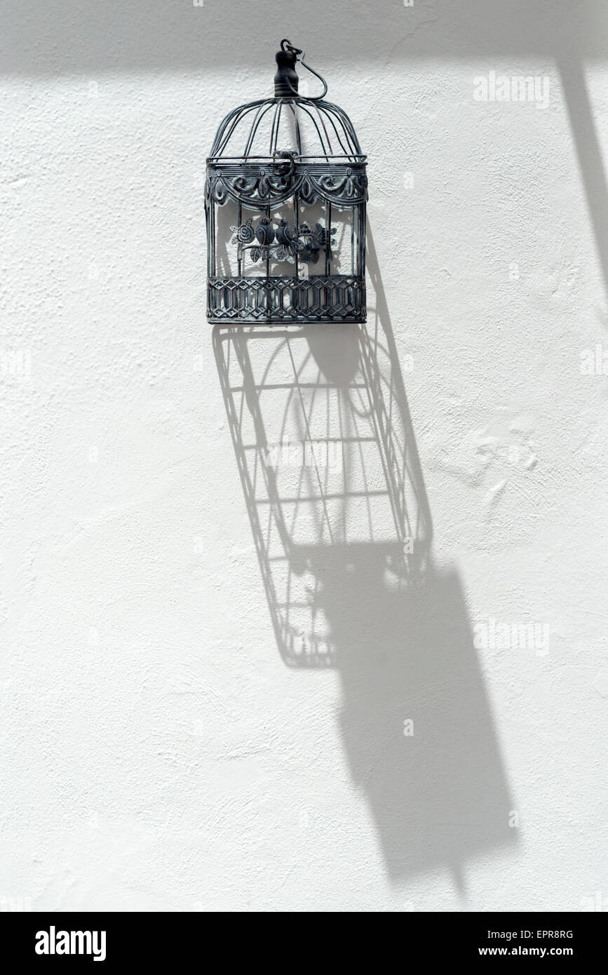 birdcage on a whitewashed wall Stock Photo
