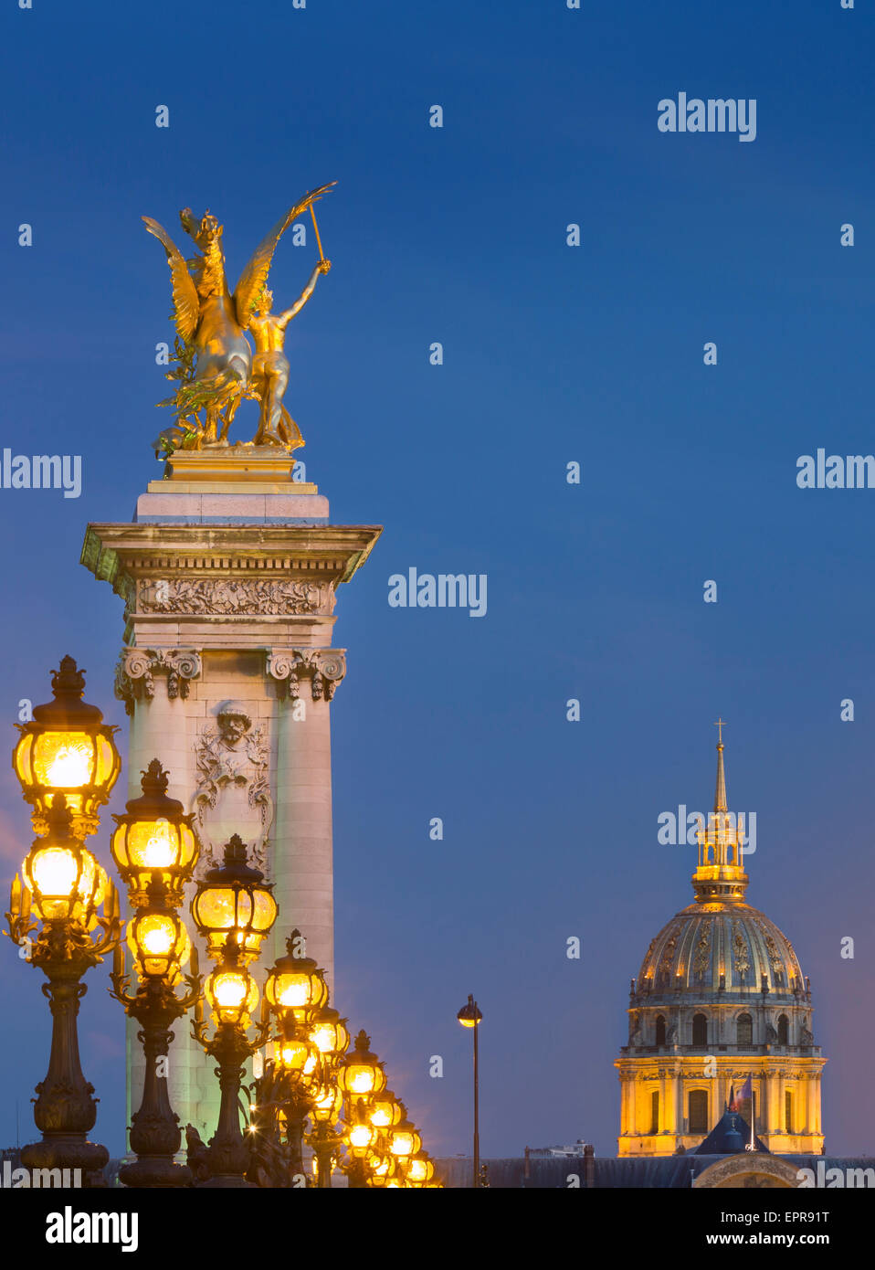 Row of lampposts along Pont Alexandre III with dome of Hotel des Invalides beyond, Paris, France Stock Photo