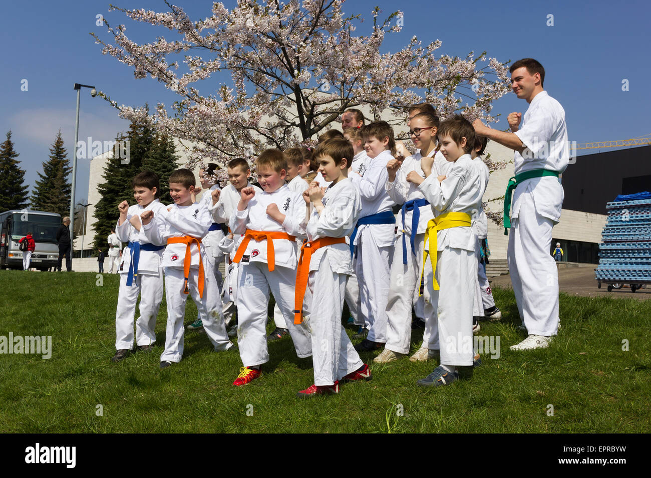 VILNIUS, LITHUANIA - APRIL 25, 2015: Young athletes of judo pose against the blossoming Japanese cherry -sakura. The holiday is Stock Photo