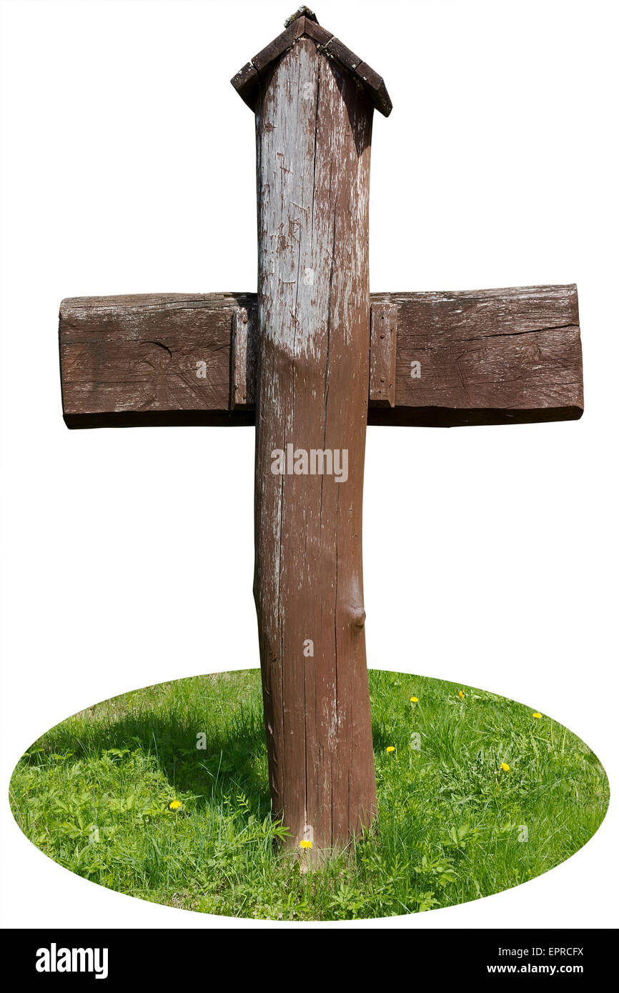 The brown wooden cross from pine logs is on a forest glade. Isolatedwith patch Stock Photo