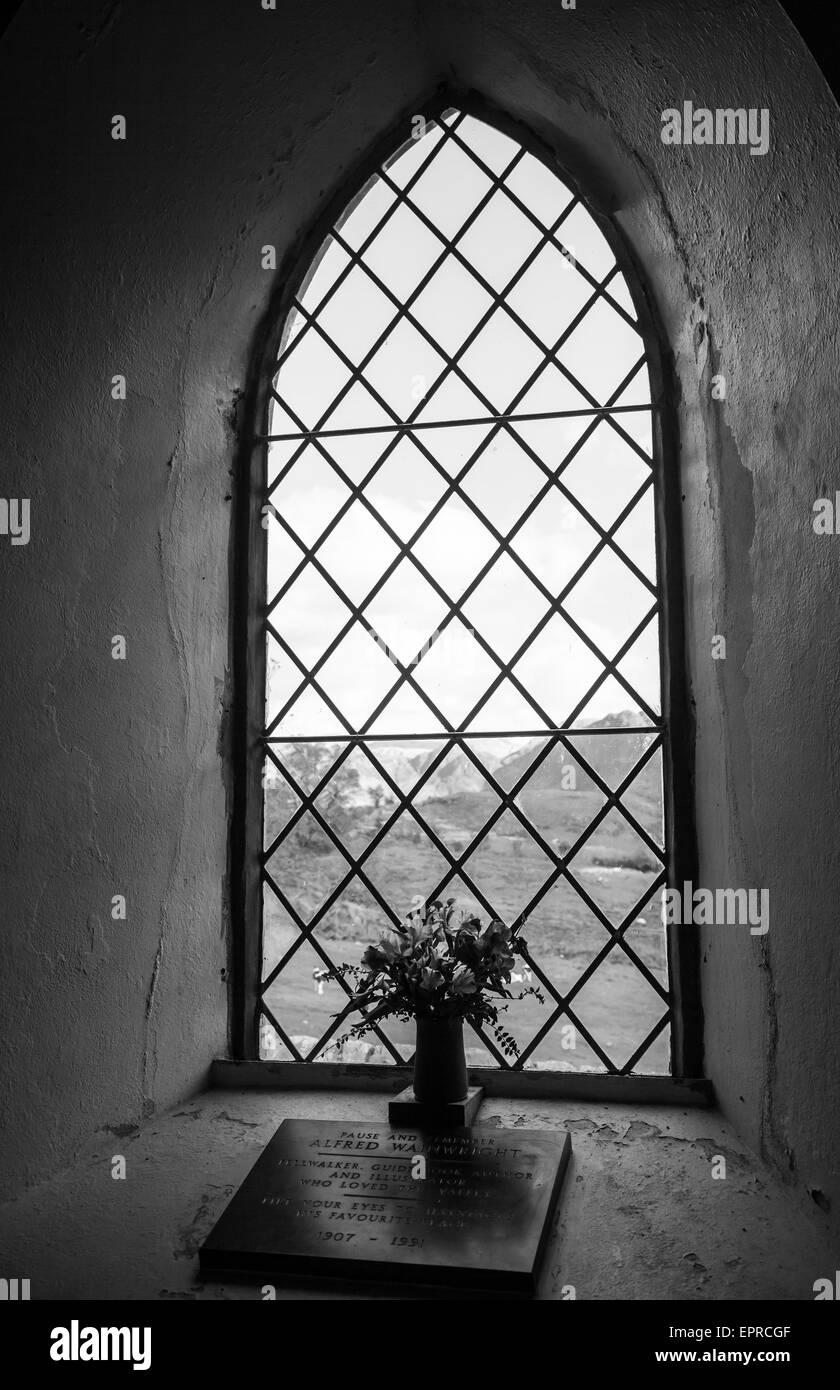 The memorial plaque window and flowers to Alfred Wainwright in St James' Church, Buttermere, Lake District, Cumbria Stock Photo