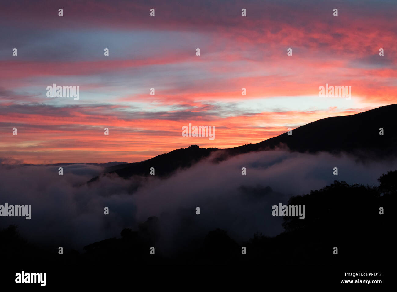 sunrise on a misty morning over the Sierra de Grazemelas, Andalucia, Spain Stock Photo