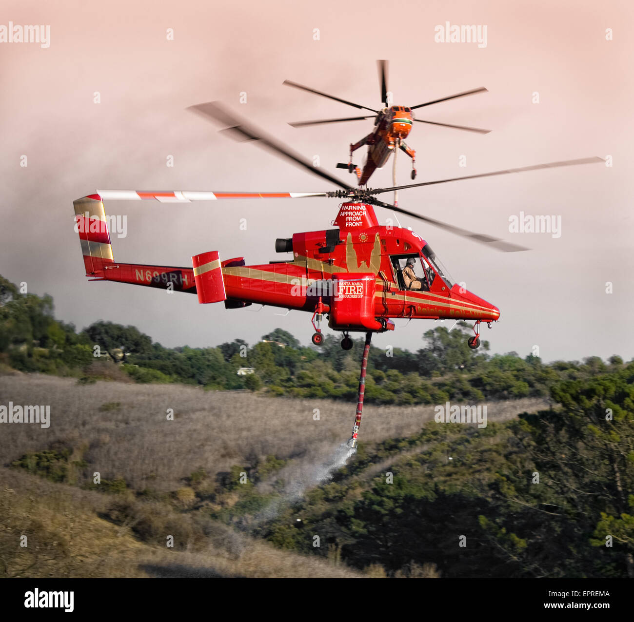 Helicopters pick up water from a reservoir while fighting wildfires in California Stock Photo