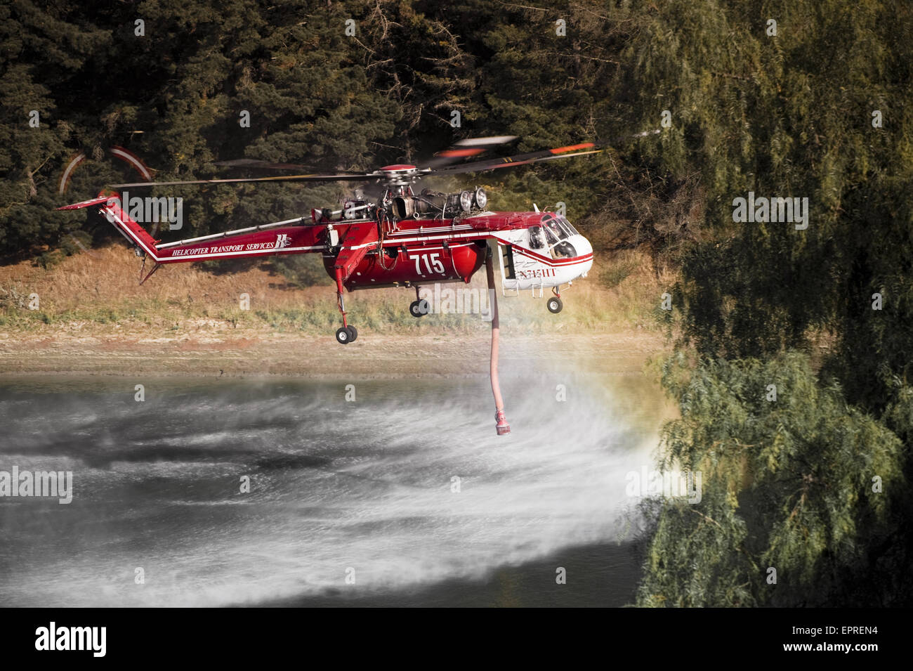 Helicopters pick up water from a reservoir while fighting wildfires in California Stock Photo