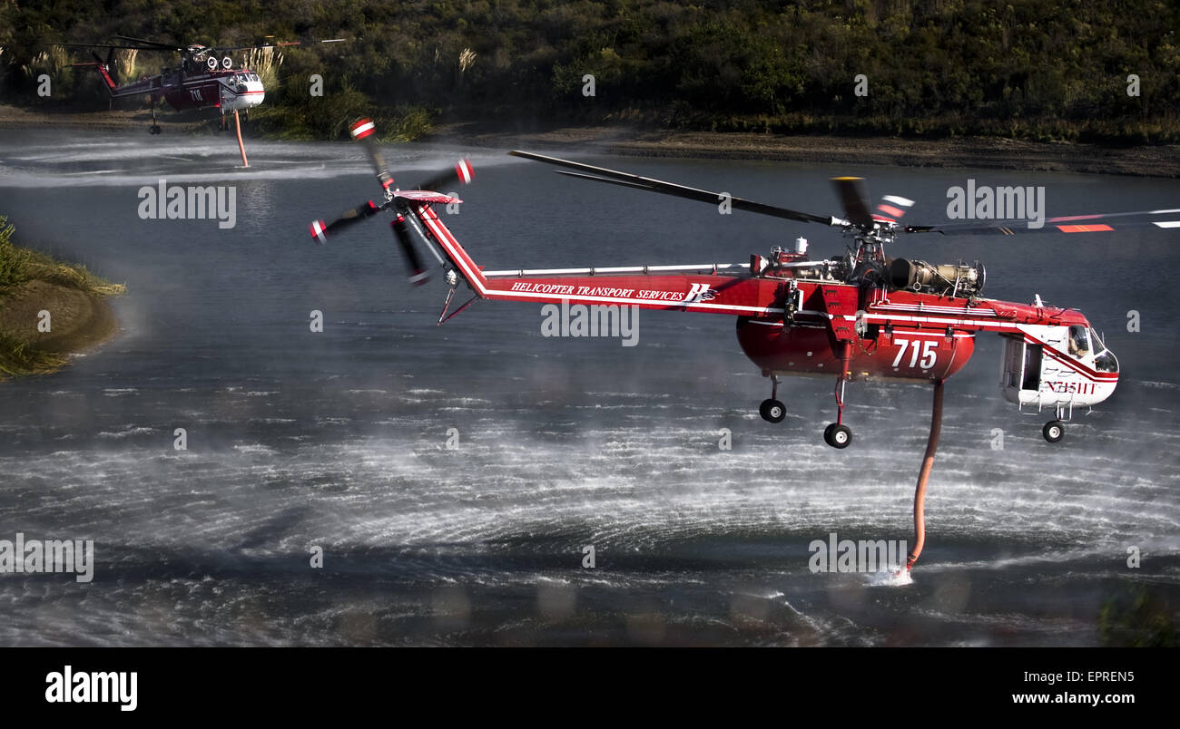 Helicopters pick up water from a reservoir while fighting wildfires in California Stock Photo