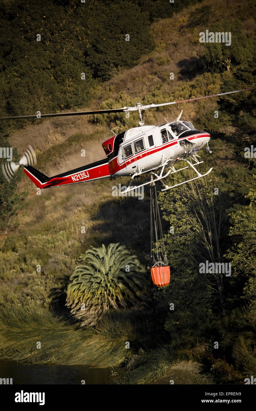 Helicopters pick up water from a reservoir while fighting wildfires in California Stock Photo
