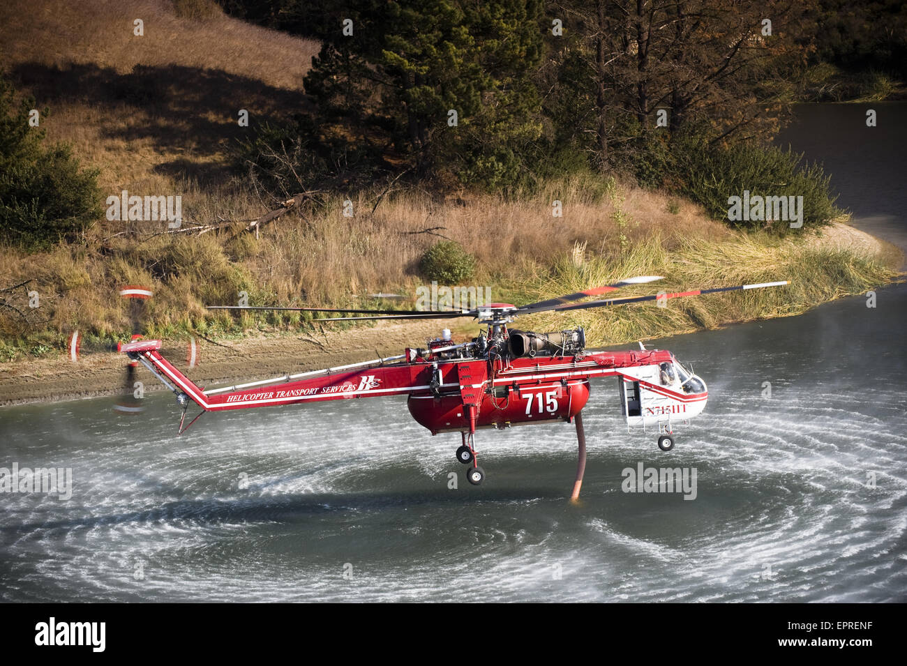 Helicopters pick up water from a reservoir while fighting wildfires in California Stock Photo