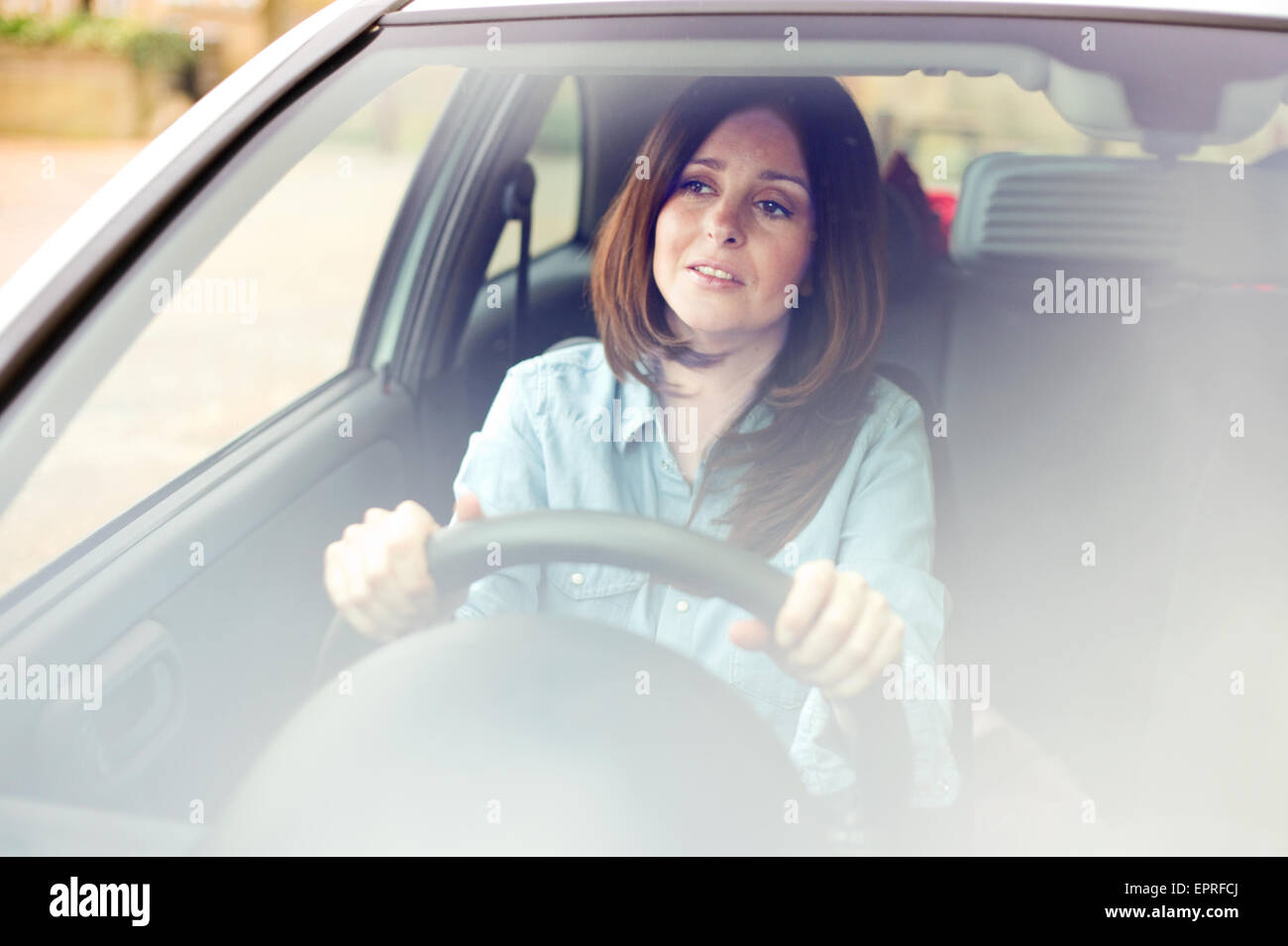 young woman driving her car looking anxious Stock Photo