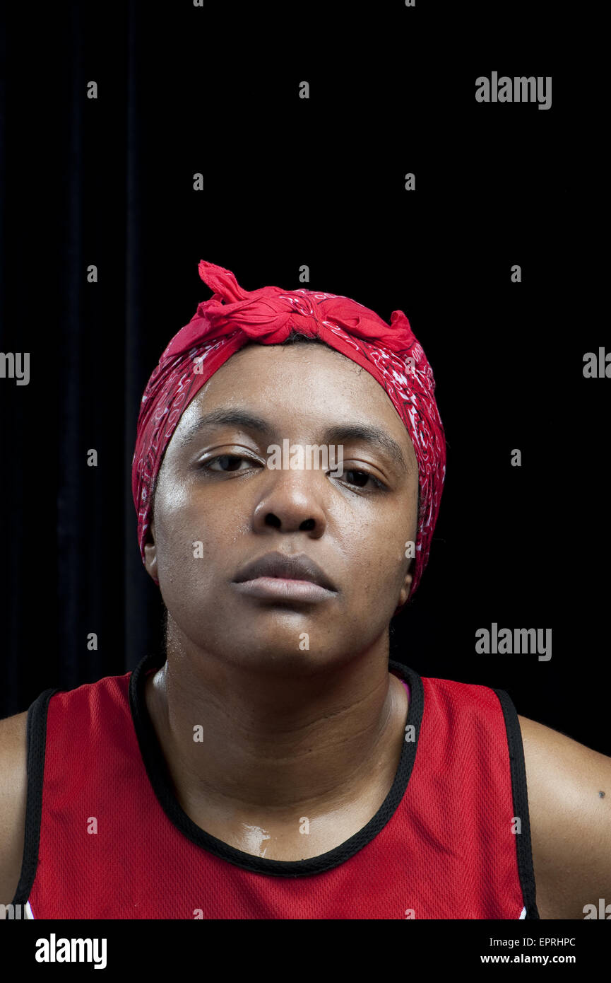 A female boxer wearing a headband stares deadpan after winning her semi