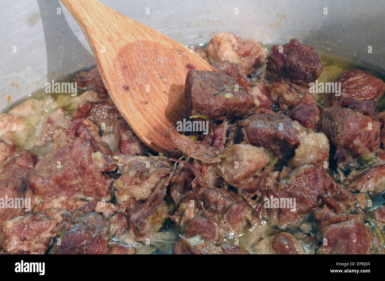 tasty meat stew in the pot of restaurant and wooden spoon Stock Photo