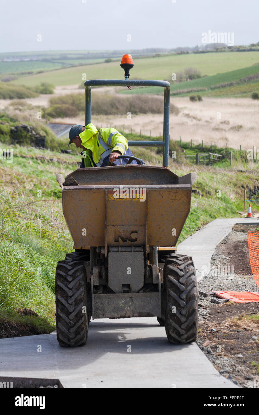 Workmen laying new path at Porthgain, Pembrokeshire Coast National Park, Wales, UK in May Stock Photo