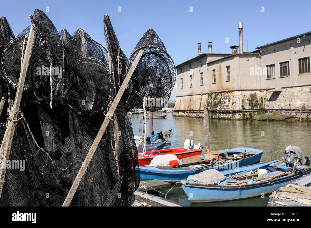 Fishing nets on the quay, in the background the fishing boats Stock Photo