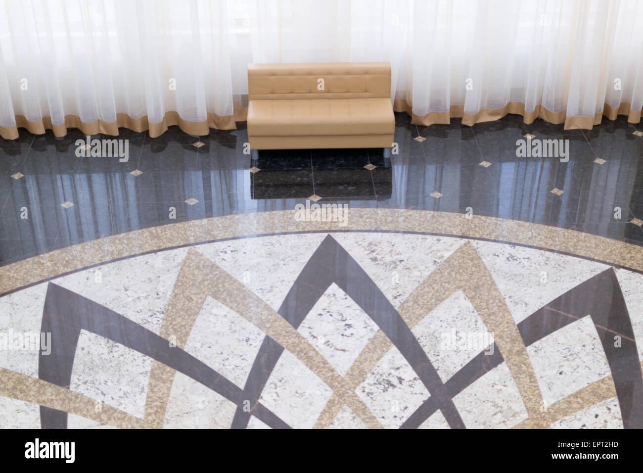 Modern sofas reflected on tiling with huge curtain and ornate floor Stock Photo