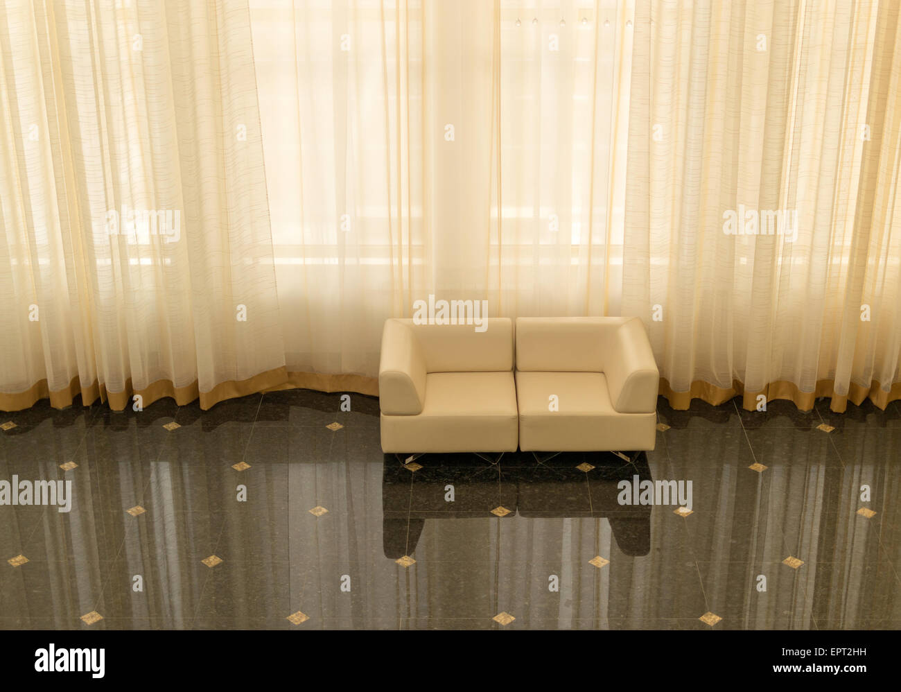 Modern sofas reflected on tiling with huge curtain Stock Photo