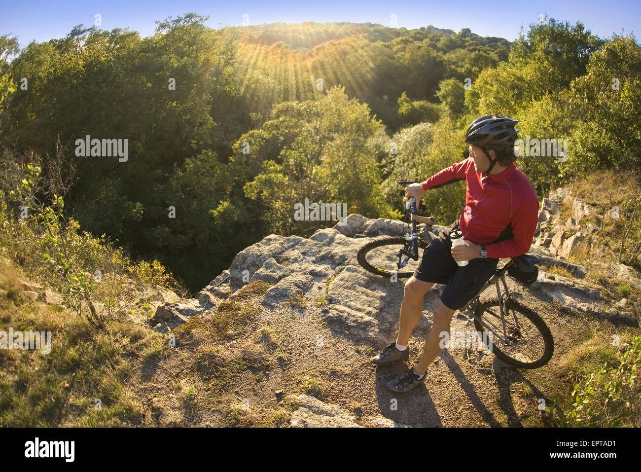 Man on bicycle taking a water break while mountain biking through