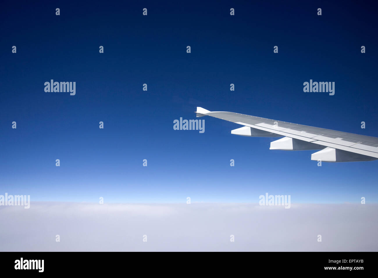 Close-up of the wing of a jet aircraft in flight above the clouds Stock ...