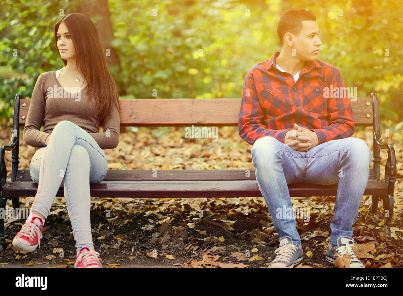 Young couple in quarrel sitting on bench in park Stock Photo - Alamy