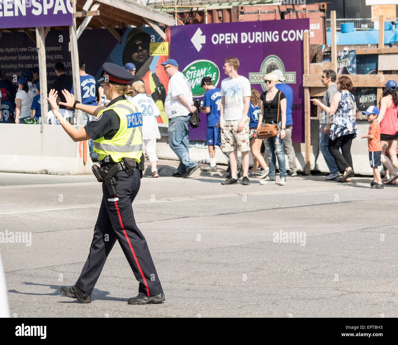 Toronto Policewoman directs traffic outside Rogers Centre after a baseball game Stock Photo