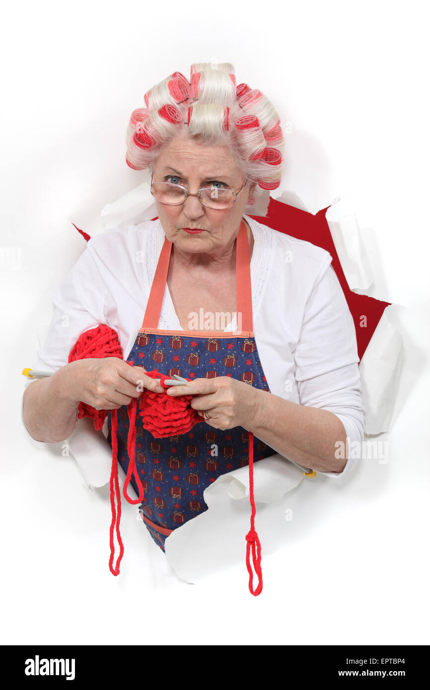 Granny with her hair in rollers and knitting Stock Photo