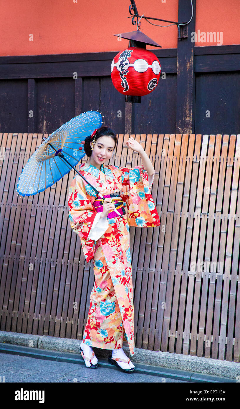 girl dressed as a geisha holding a parasol in Japan Stock Photo