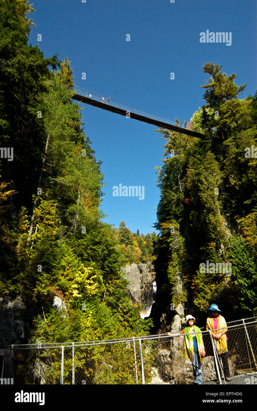 Visitors crossing Park Canyon Ste Anne River pedestrian suspension bridges Stock Photo