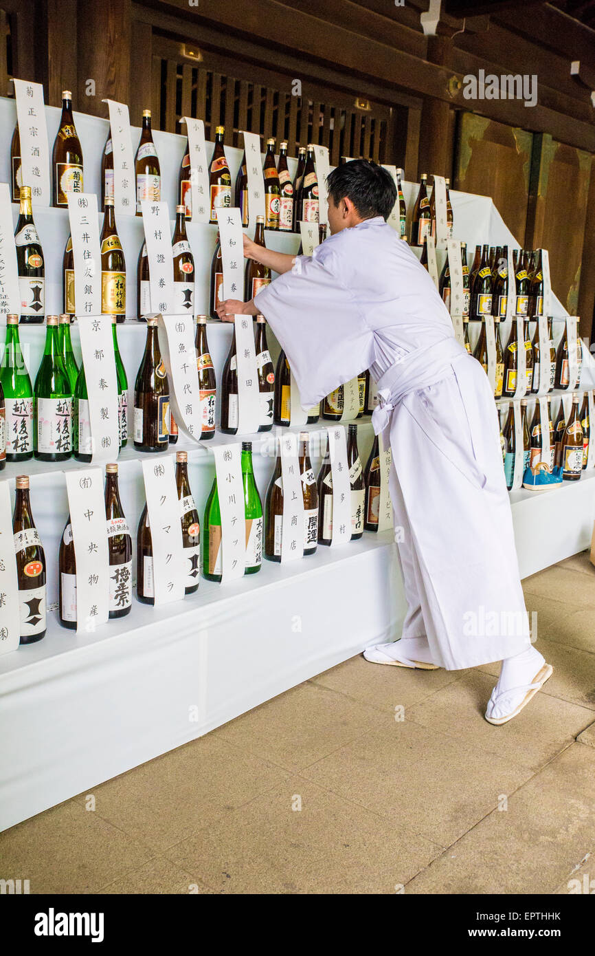 Local Japanese man in front of bottles of sake Stock Photo
