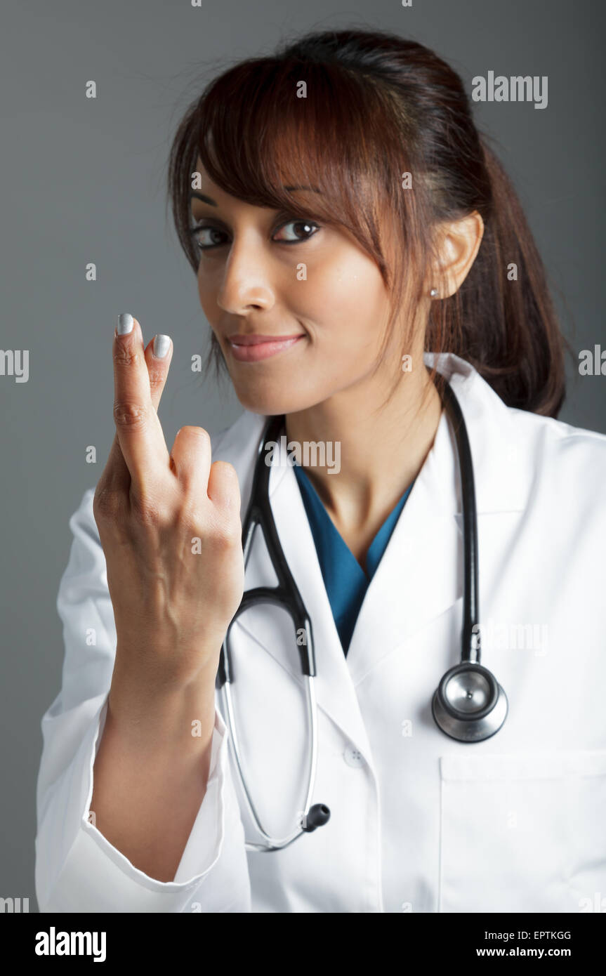 Attractive Indian doctor woman posing in a studio in front of a ...