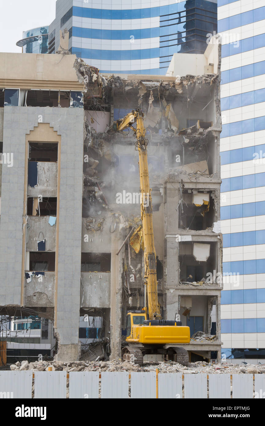 Concrete frame building in Doha Qatar being demolished by hydraulic crusher equipment Stock Photo
