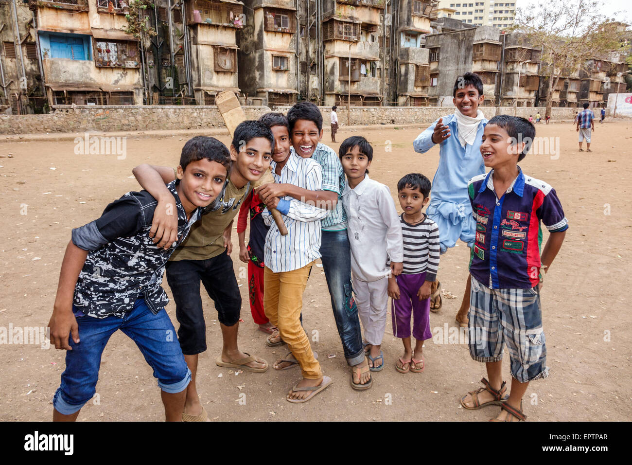 Mumbai India,Dharavi,Shahu Nagar Road,slum,dirt lot,cricket field pitch,male boy boys kids children friends,playing,bat,India150228034 Stock Photo