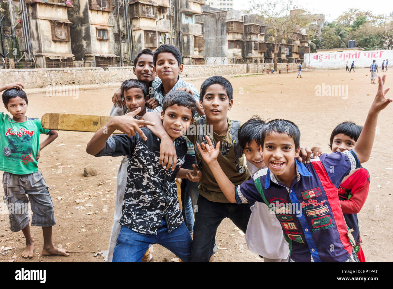 Mumbai India,Dharavi,Shahu Nagar Road,slum,dirt lot,cricket field pitch,male boy boys kids children friends,playing,bat,hand signals,India150228035 Stock Photo