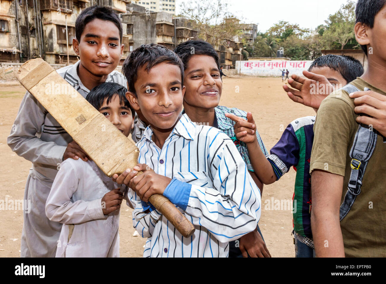 Mumbai India,Indian Asian,Dharavi,Shahu Nagar Road,slum,dirt lot,cricket field pitch,male boy boys lad lads kid kids child children,friends,playing,ba Stock Photo