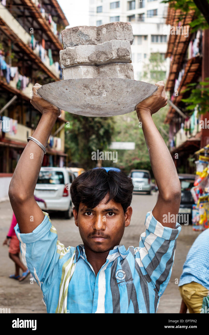 Mumbai India,Dharavi,Shahu Nagar Road,slum,low income,poor,poverty,man men male,working,carrying,concrete blocks,India150228098 Stock Photo