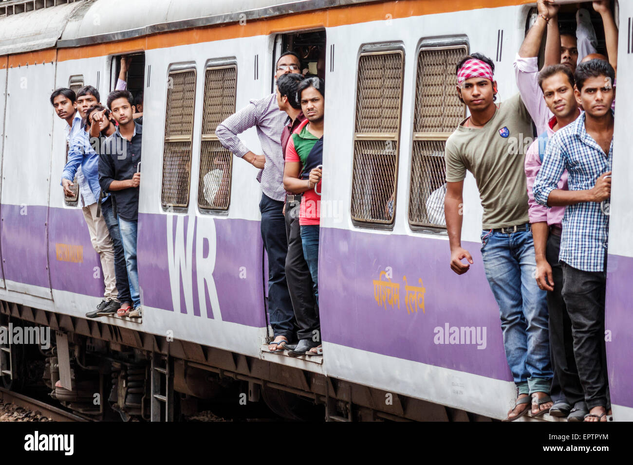 Mumbai India,Dharavi,Mahim Junction Railway Station,Western Line,train,riders,passenger passengers rider riders,hanging,open door,man men male,India15 Stock Photo