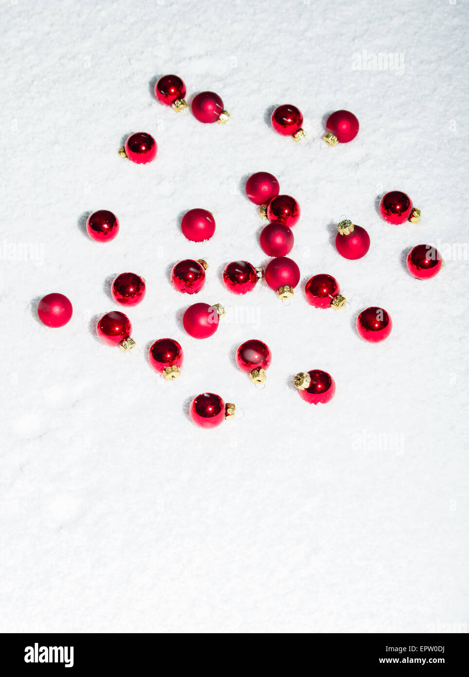 Red Christmas ornaments on white snow Stock Photo - Alamy