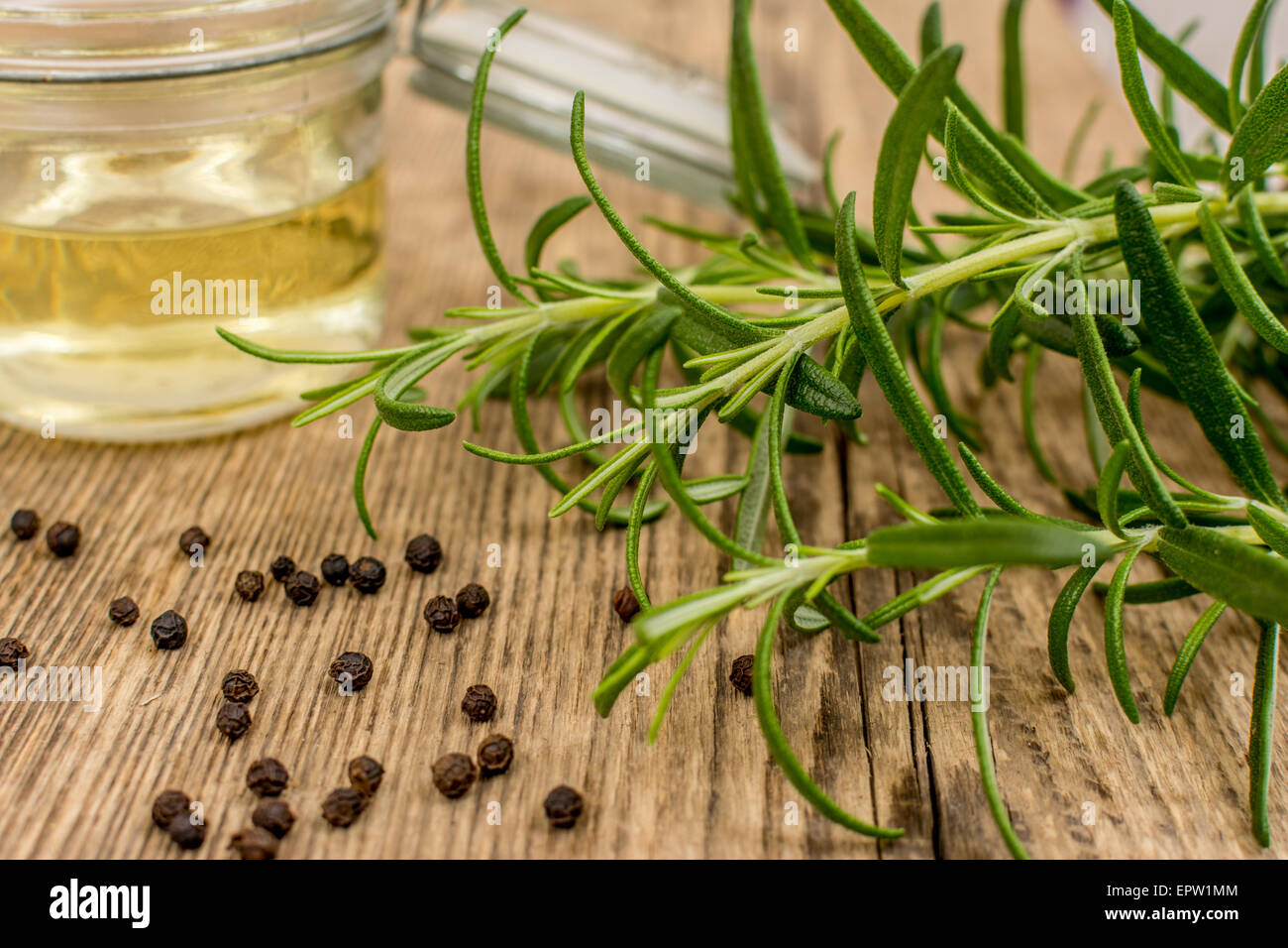 Herb rosemary with oil on wood table Stock Photo