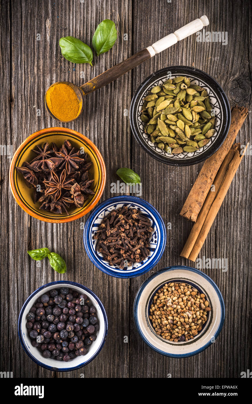 Different spices in ceramic bowls on a wooden table Stock Photo