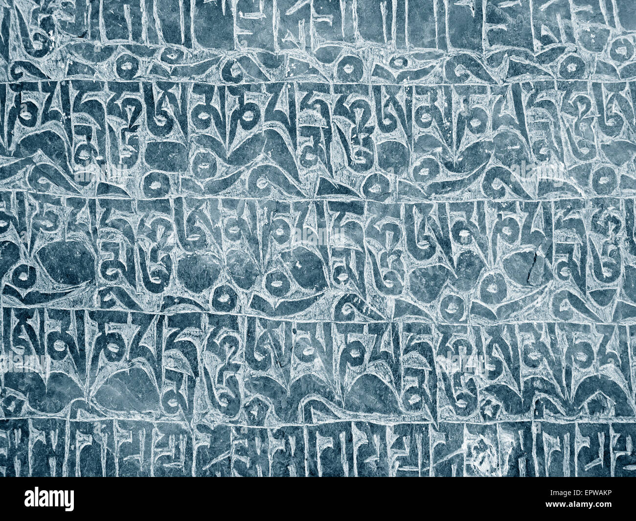 Buddhist mantra carved in stone as background Stock Photo
