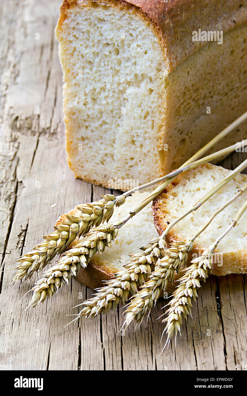 a loaf of bread and wheat ears in the background Stock Photo - Alamy