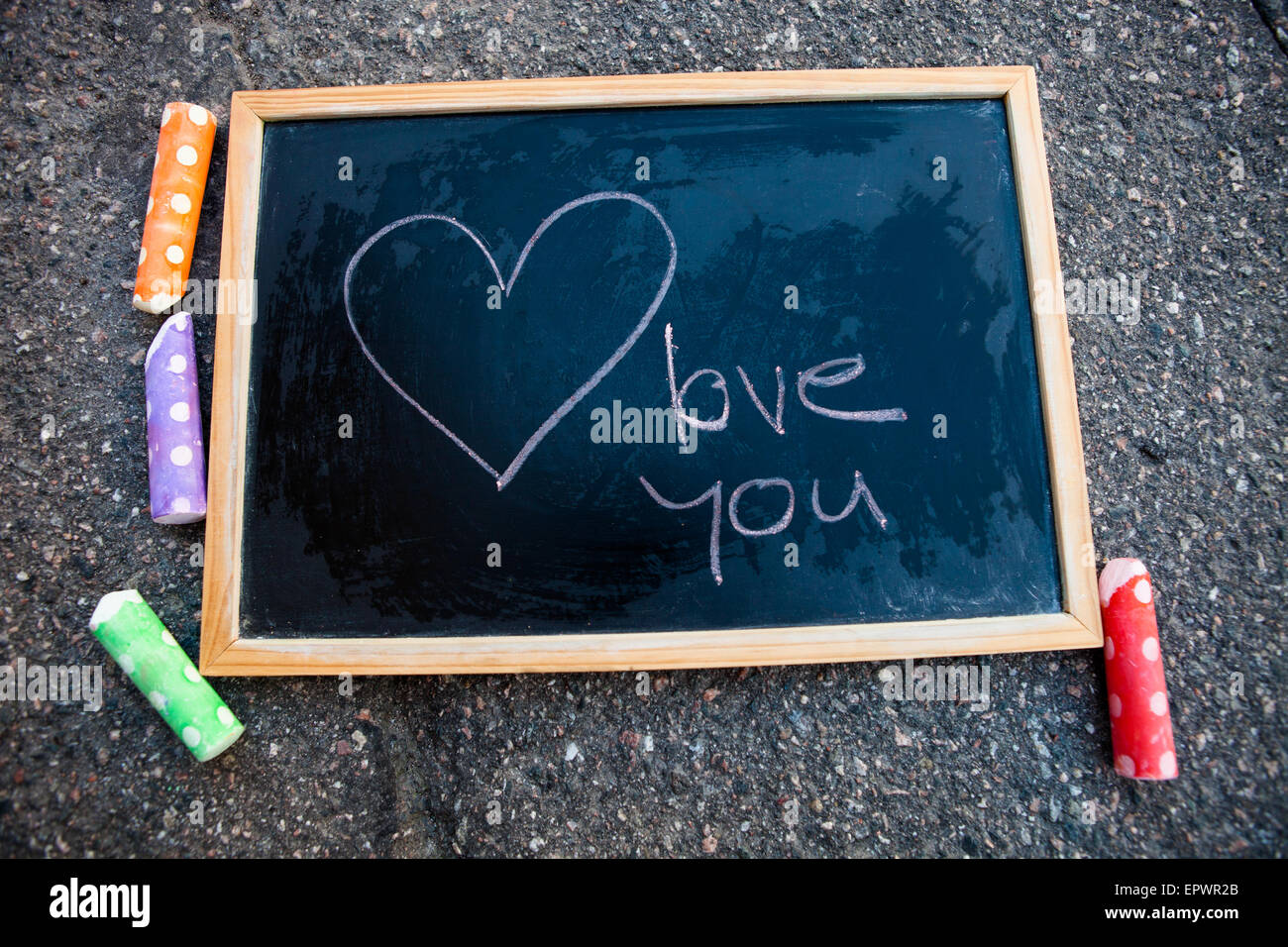 I love you message and a heart on chalkboard and colorful street chalk Stock Photo