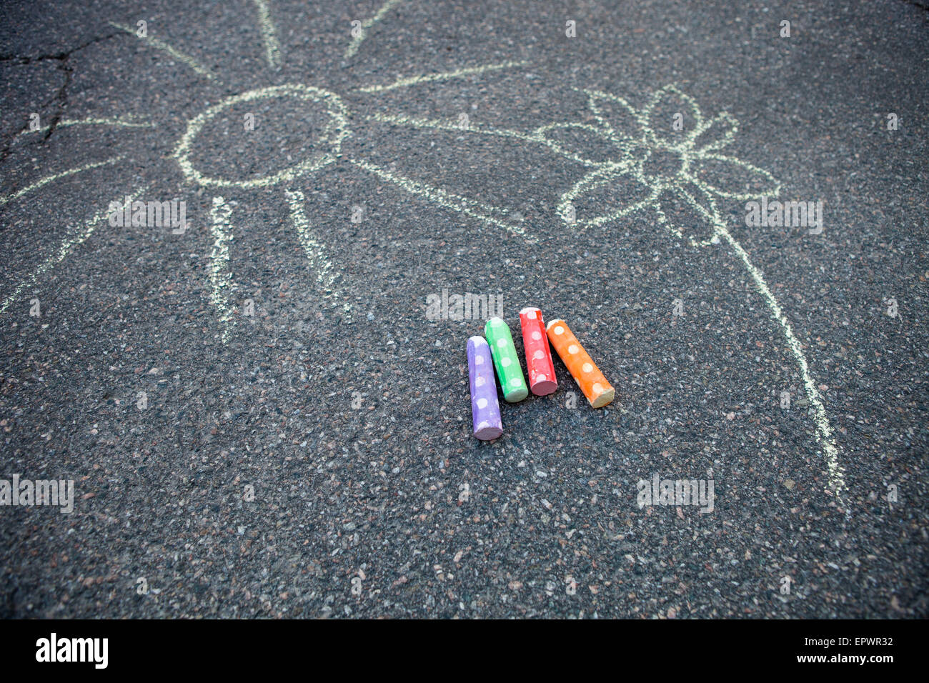 Sun and flower drawn to the ground with colorful street chalk Stock Photo